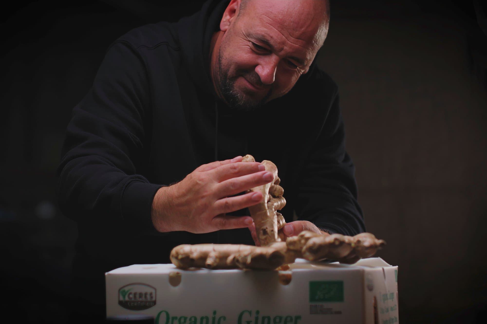 Checking a ginger root by hand before it is packed